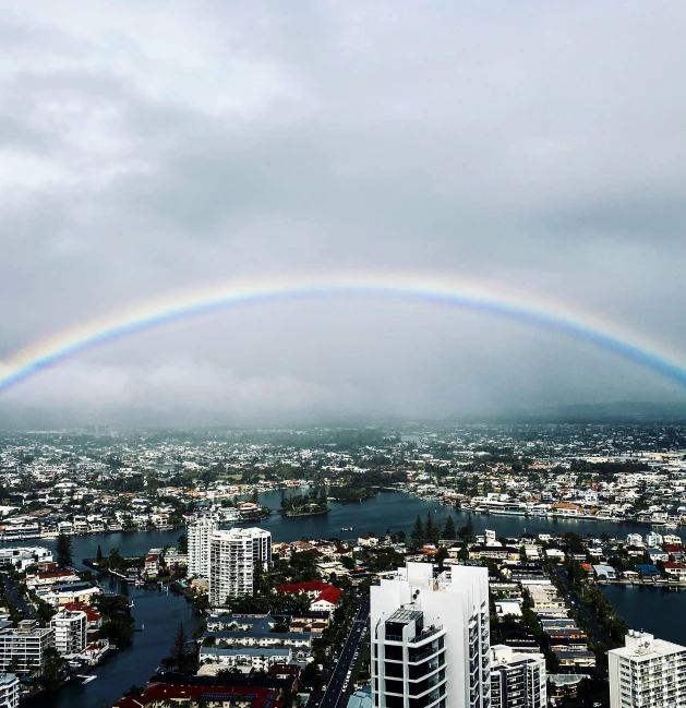 two rainbows can be seen over a large city