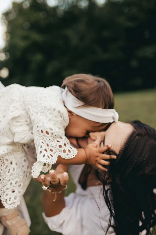 two little girls playing together while sitting in the grass