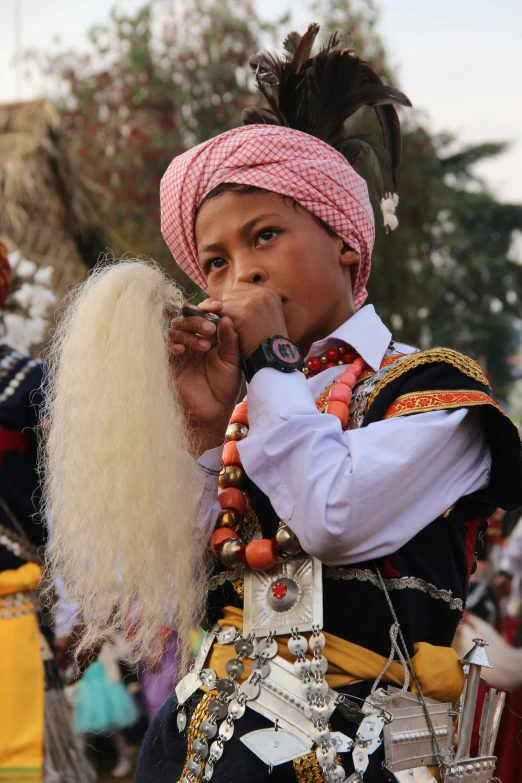 a girl in a colorful dress blows a pipe