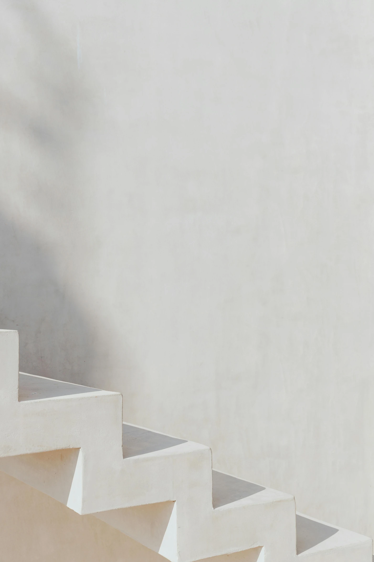 man riding a skateboard on the side of a white set of stairs