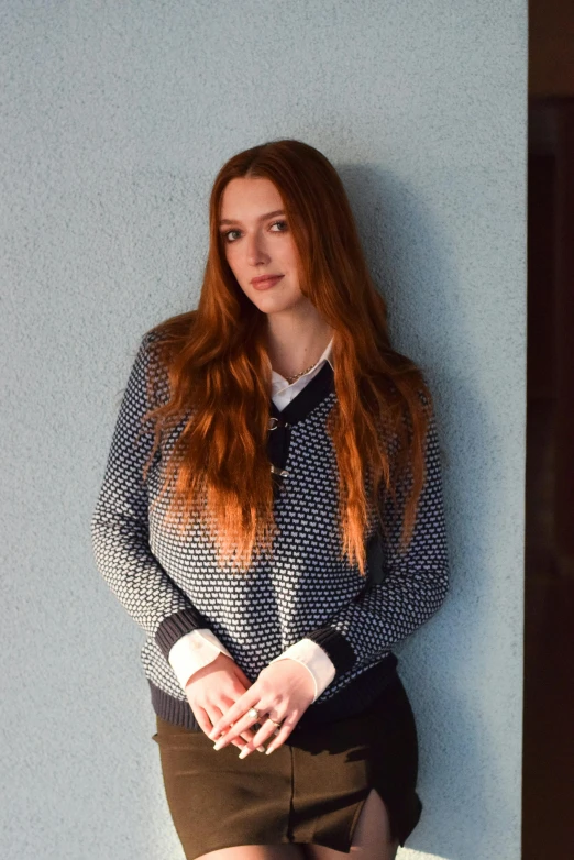 a woman in shorts is leaning against a wall