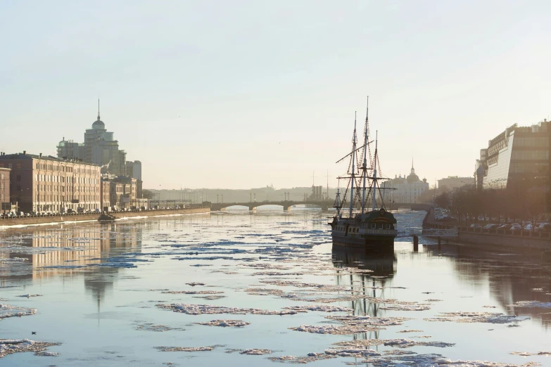 two ships floating in the water next to a bridge