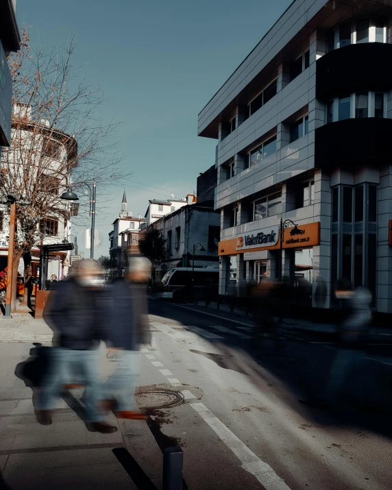 several people walking across the road in the evening