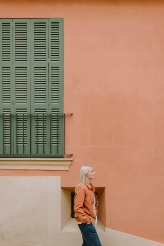 a person standing on stairs in front of a pink building