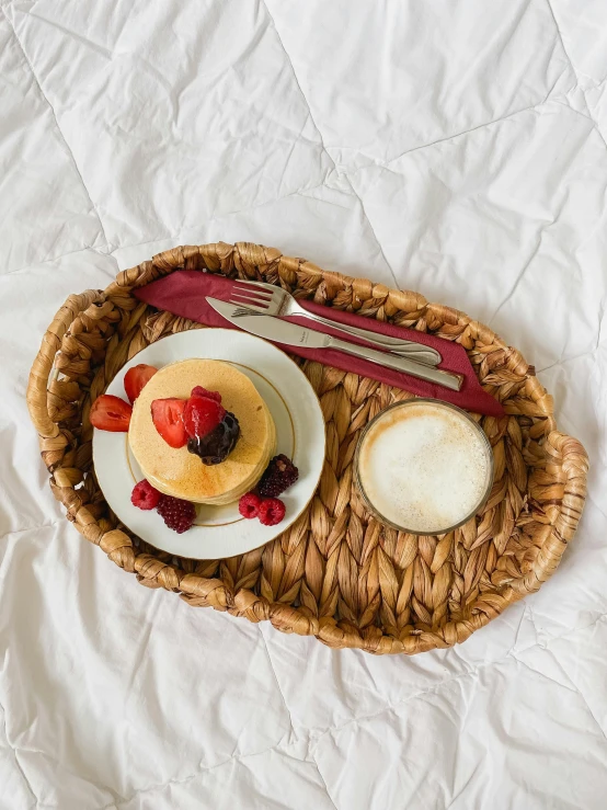 a basket containing two pastries and fruit on top