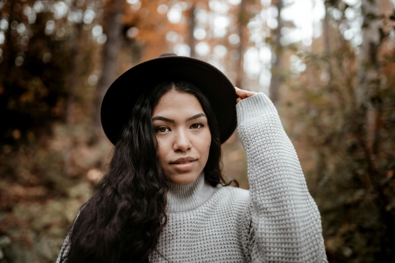 a young woman wearing a black hat poses for a portrait