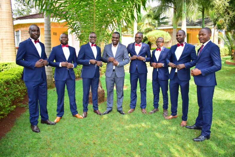 a group of men in suits and ties holding hands together