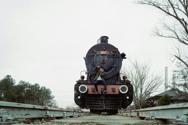 an old, rusty train is on the track with a broken bridge beside it