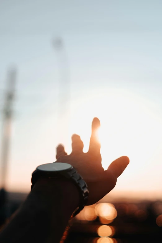 someone holding out their hand at sunset