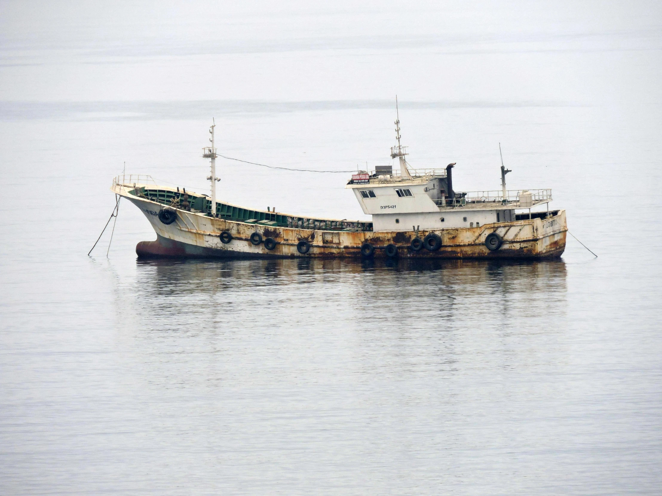 a rusted, rusted boat that is sitting in the water