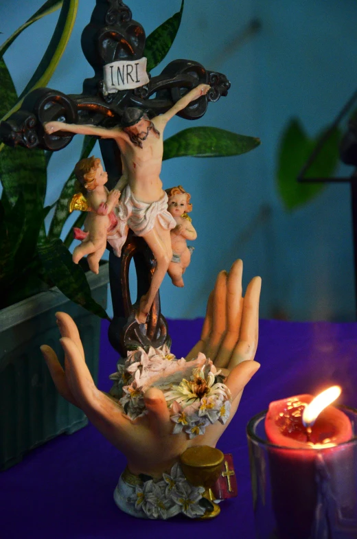 a hand holding an elaborate figurine above another hand