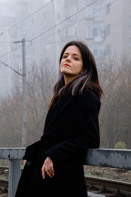 woman standing on bridge looking up at soing