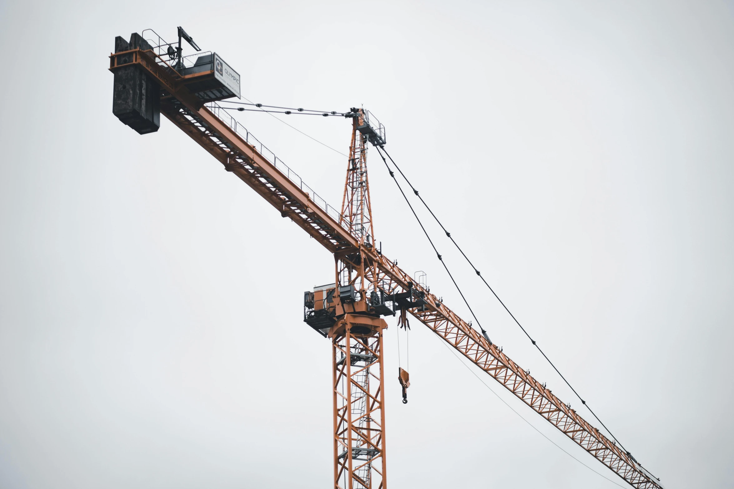 several cranes in an empty area and some gray skies