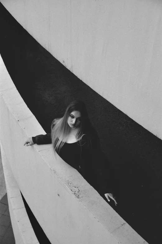 a woman laying down on a boat under a black and white sky