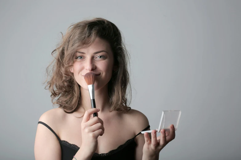 a young woman is holding up a tube in front of her face