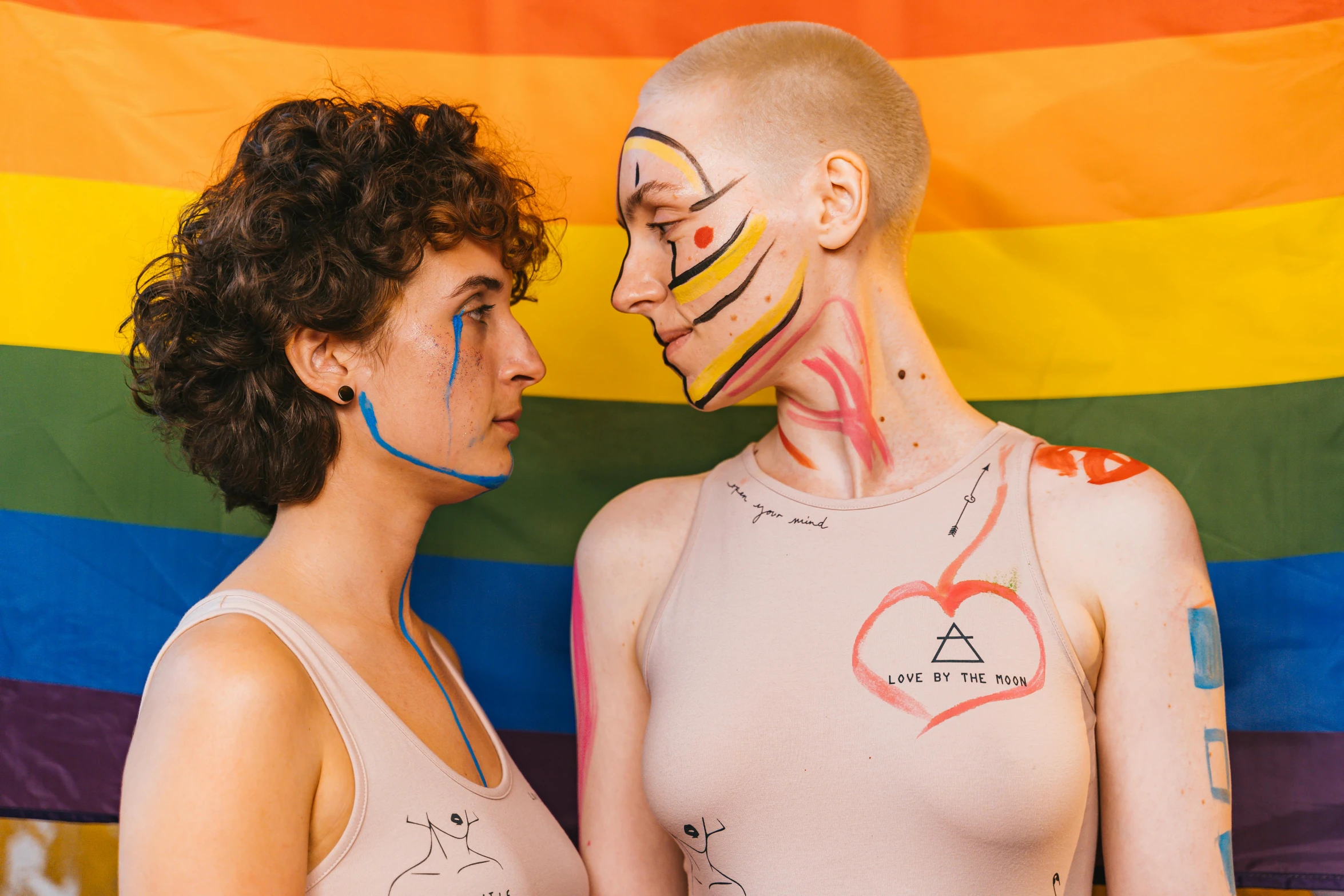 two women wearing body paint face to face