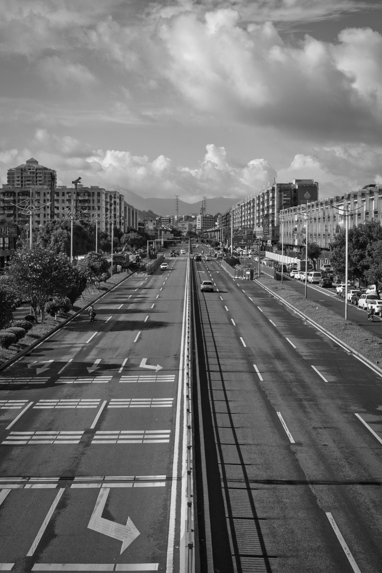 a deserted street lined with tall buildings in the distance