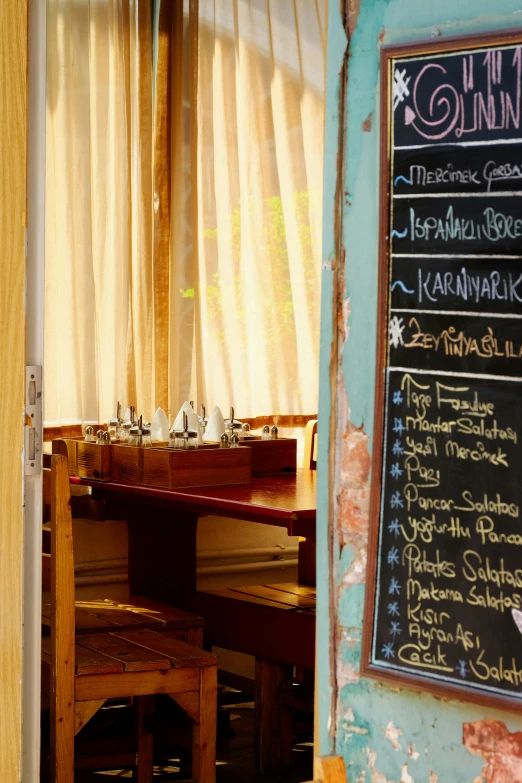 a menu on a chalkboard is beside a chair