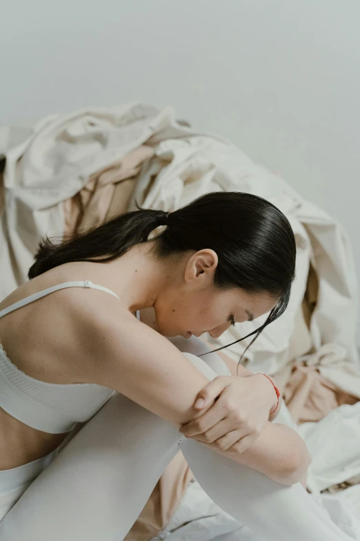 a woman wearing white tights on top of a bed