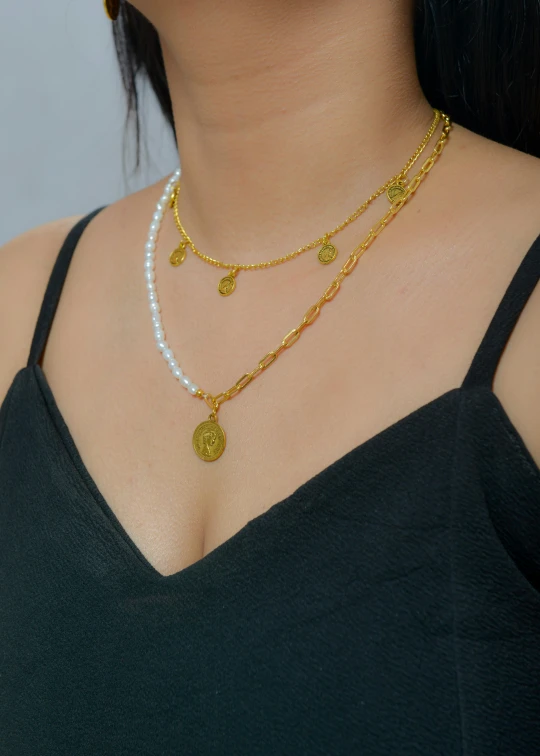 a woman wearing a gold and white necklace