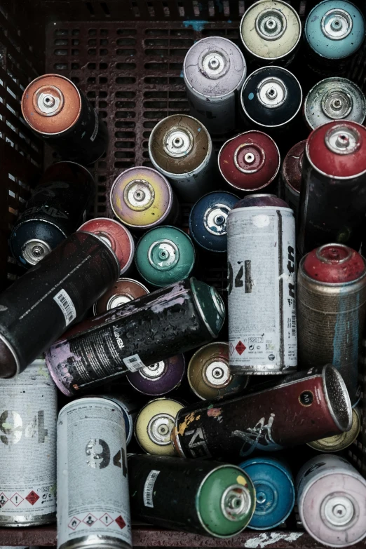 various cans and tubes sitting together in an old crate