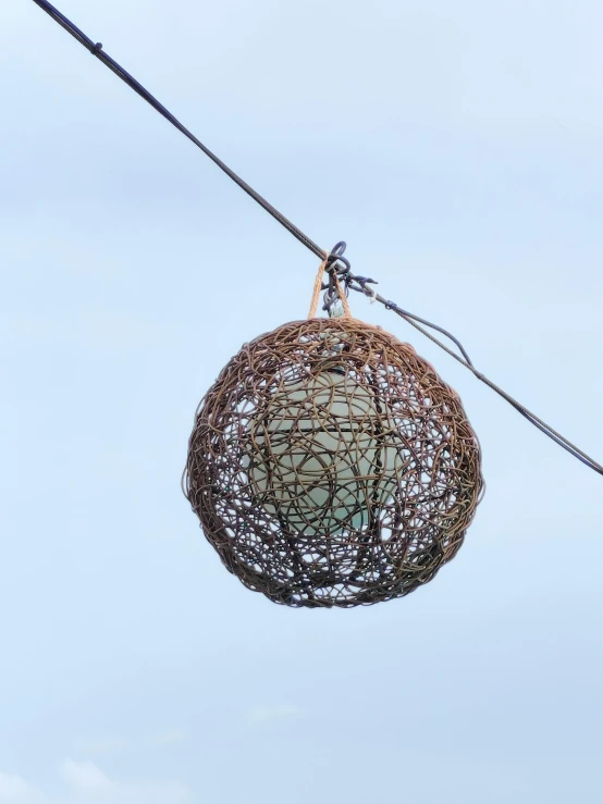 an intricate light bulb on power lines