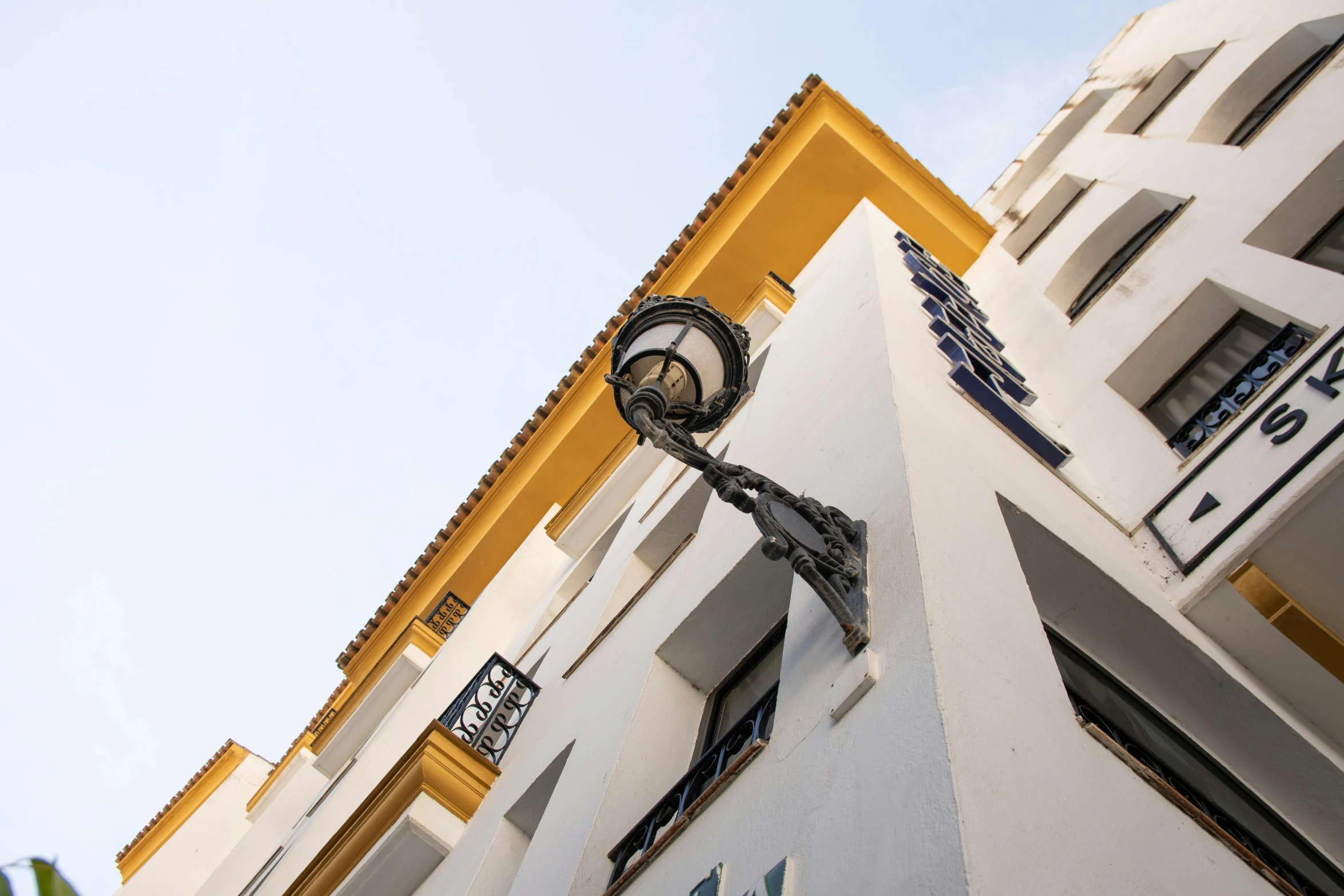 a tall white building with some blue and yellow trim