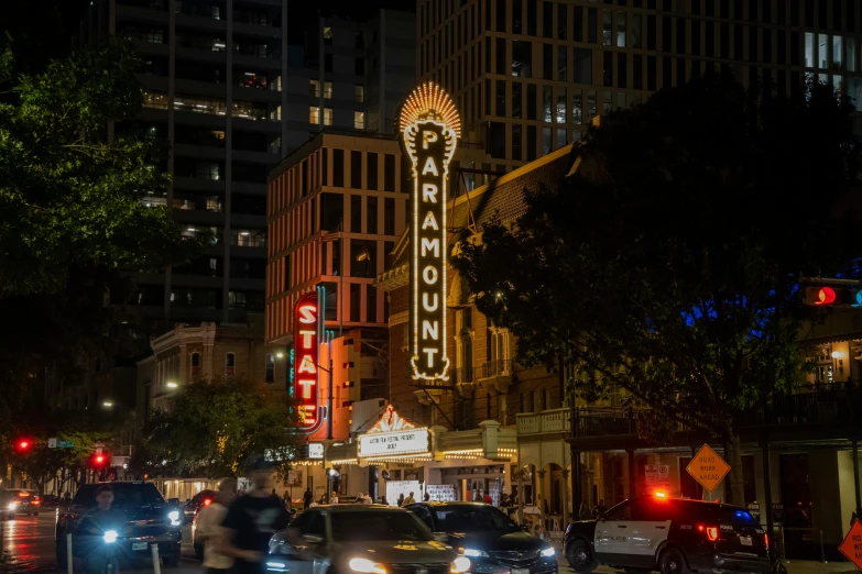 traffic on a busy street near large buildings at night