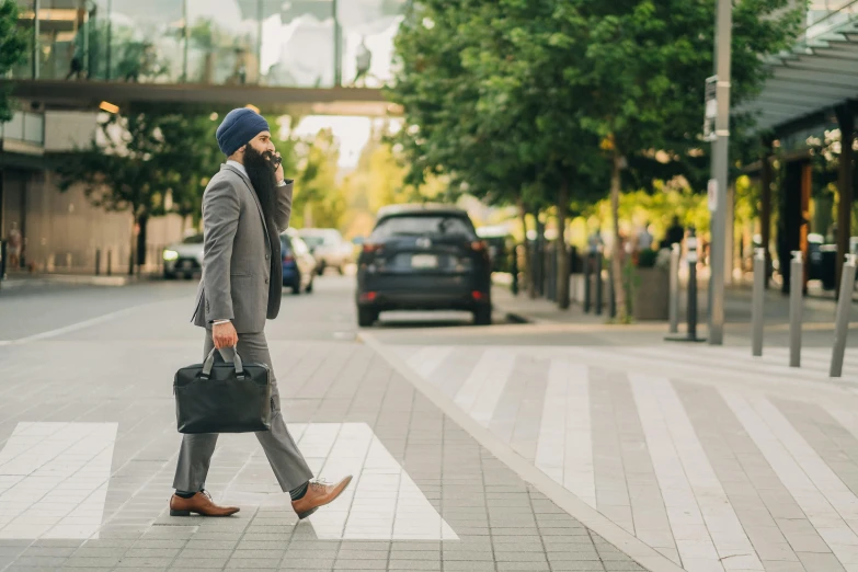 a man in a business suit crossing the street in front of a black car