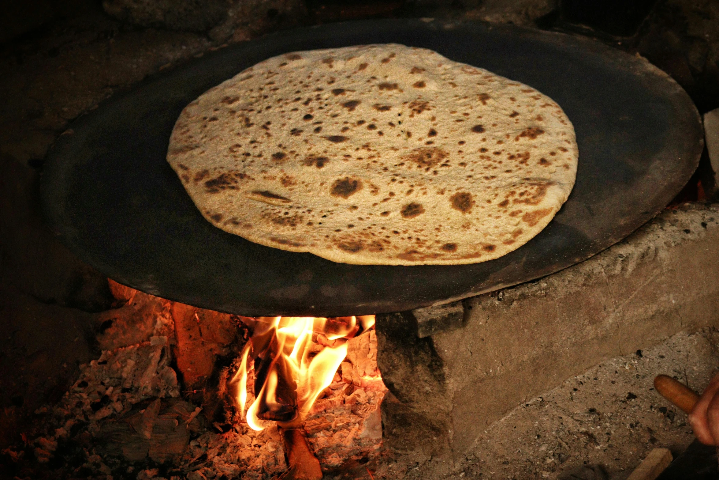 tortilla cooking in an outdoor fire pit