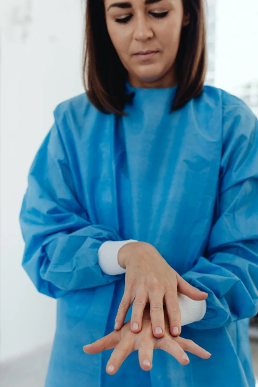 woman with hands wrapped around object in blue coat