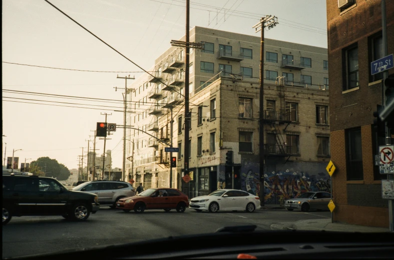 a street view with cars, a traffic light and tall buildings