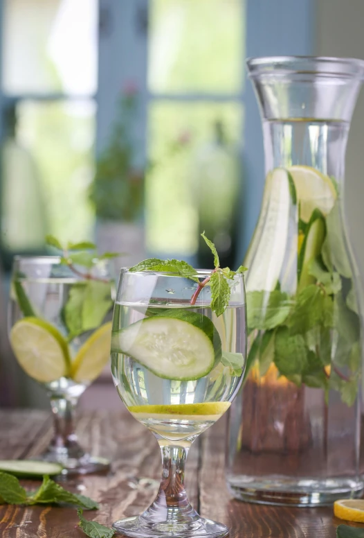 a bottle of wine and some glasses of cucumbers