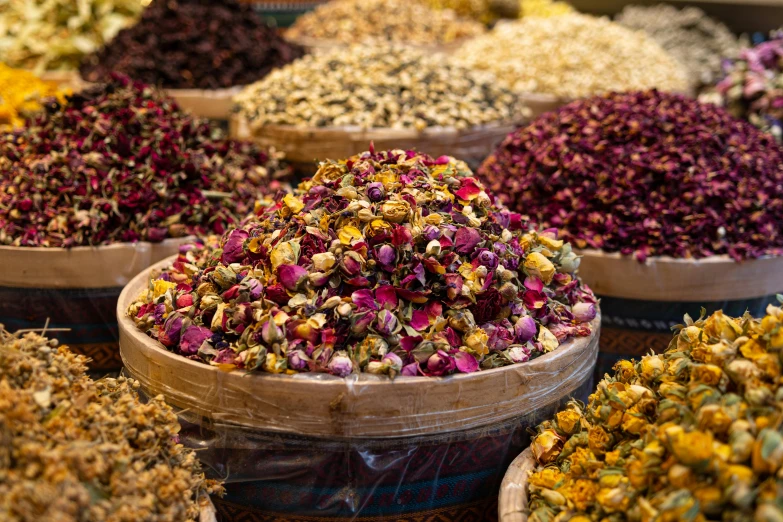 many kinds of dried flowers sitting in wooden baskets