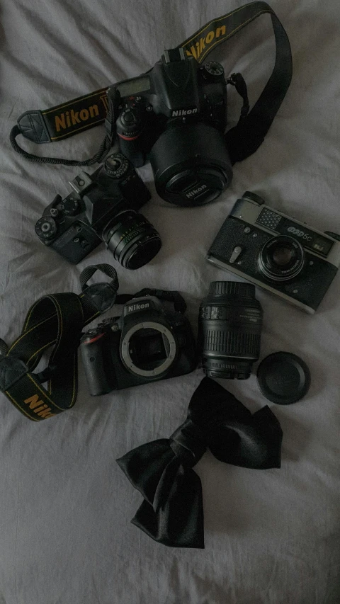 various cameras and other accessories layed out on the bed