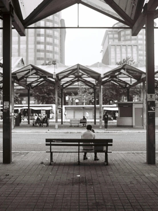 a man sitting on top of a bench under a tent