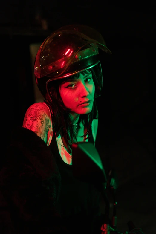 a woman in motorcycle gear is glowing in the dark