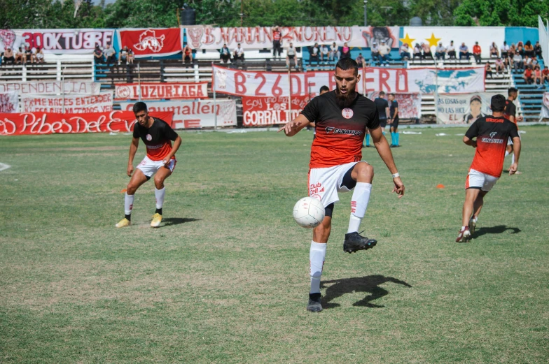 a man kicking a soccer ball down a field