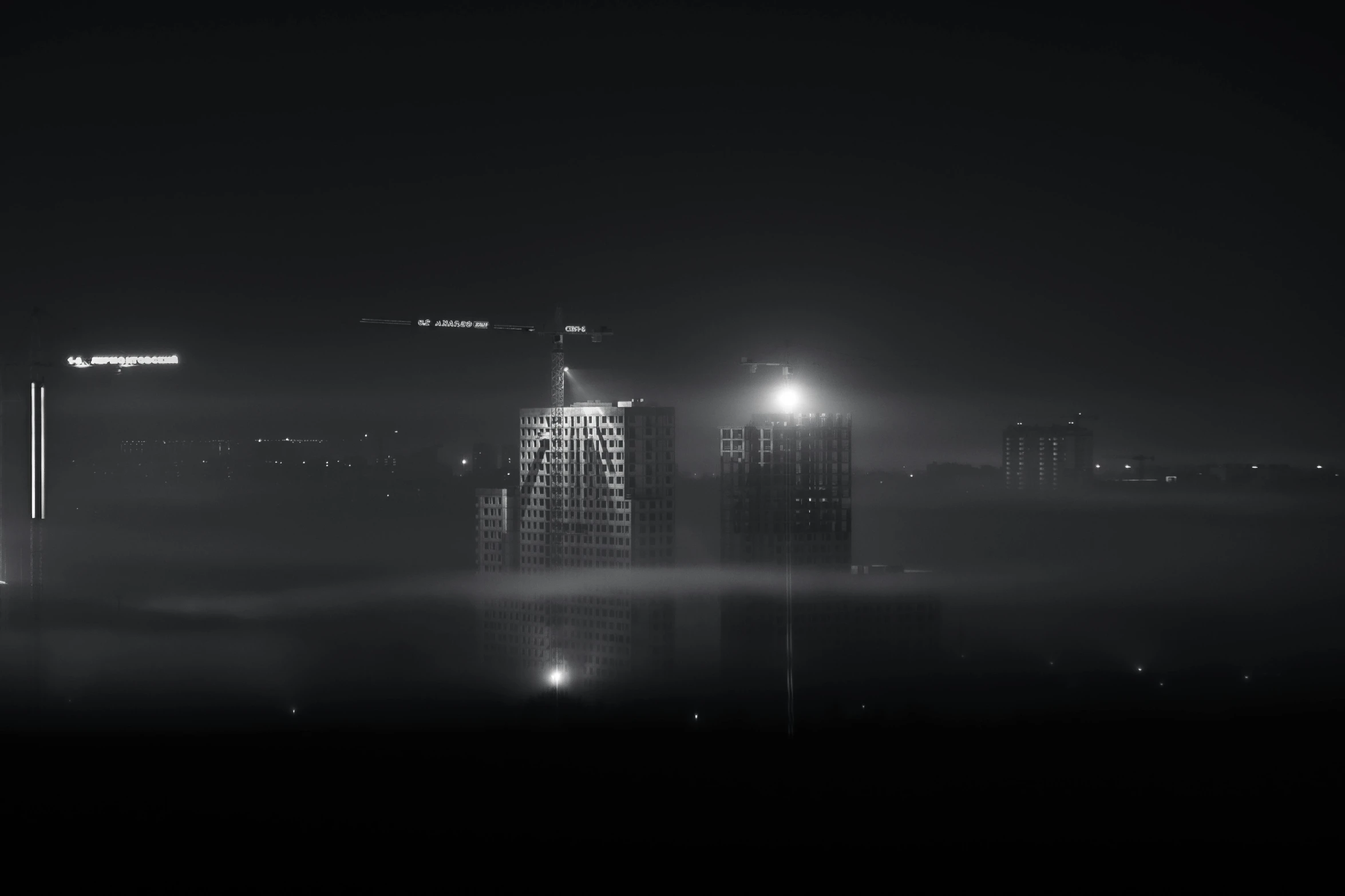 a black and white image with fog on the water