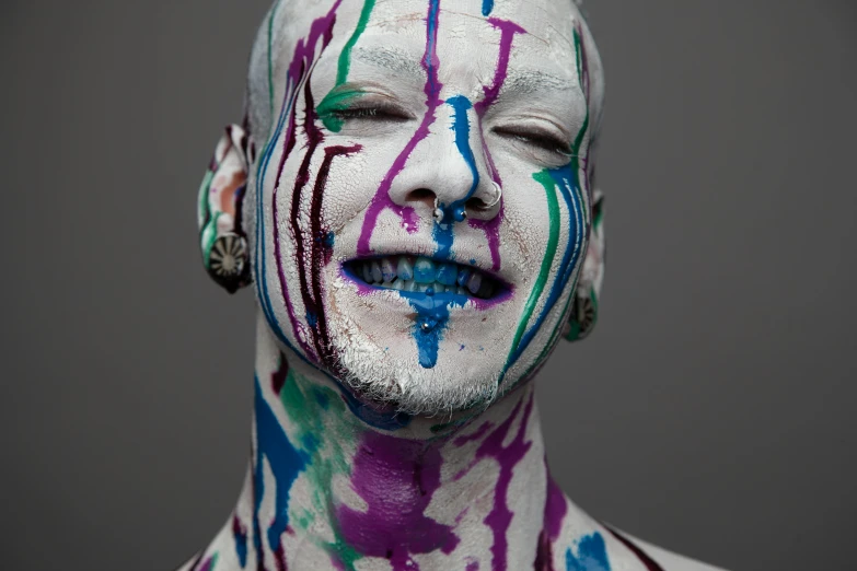 a person with paint on his face and a necklace around his neck