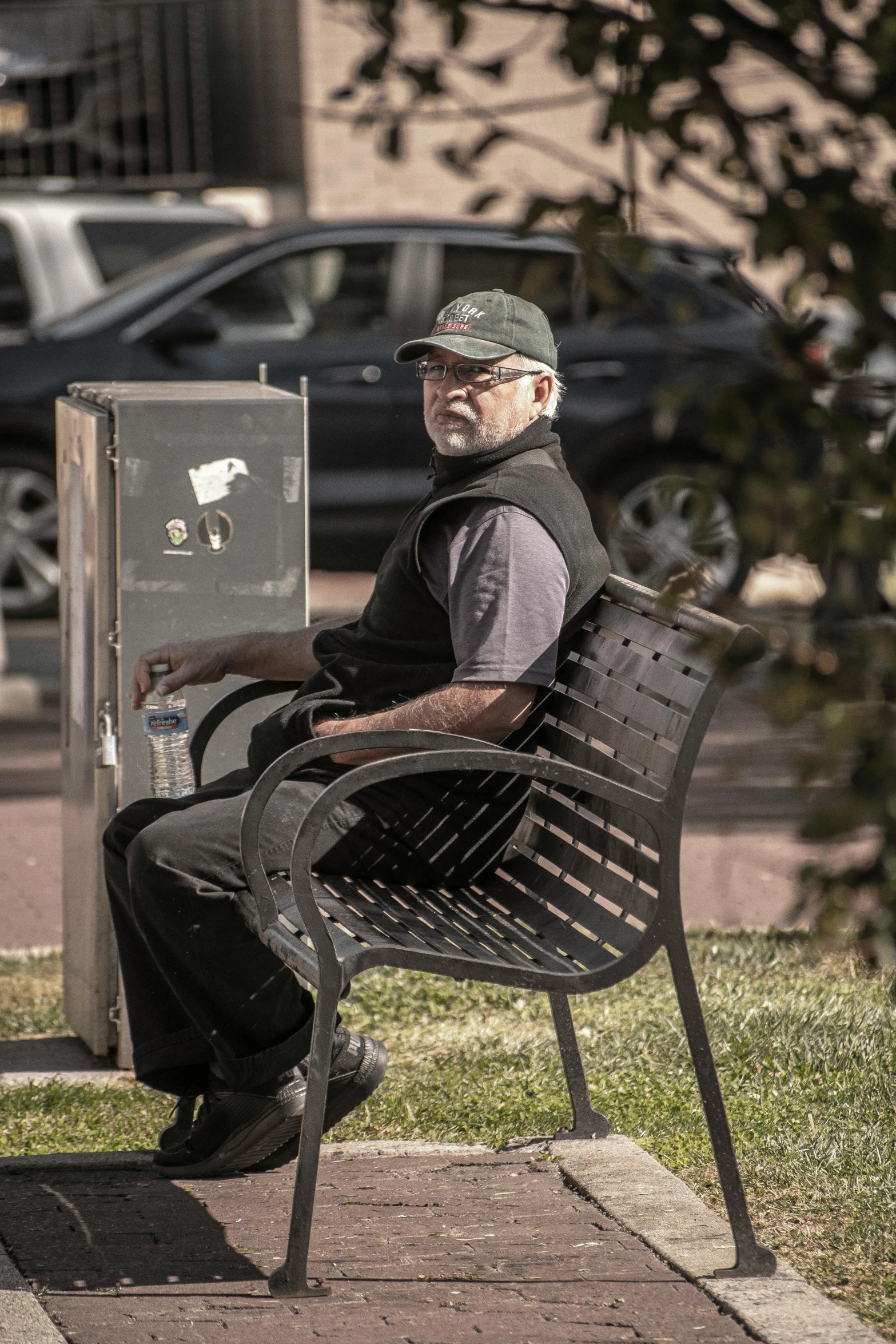 an older man sitting on a bench in the park