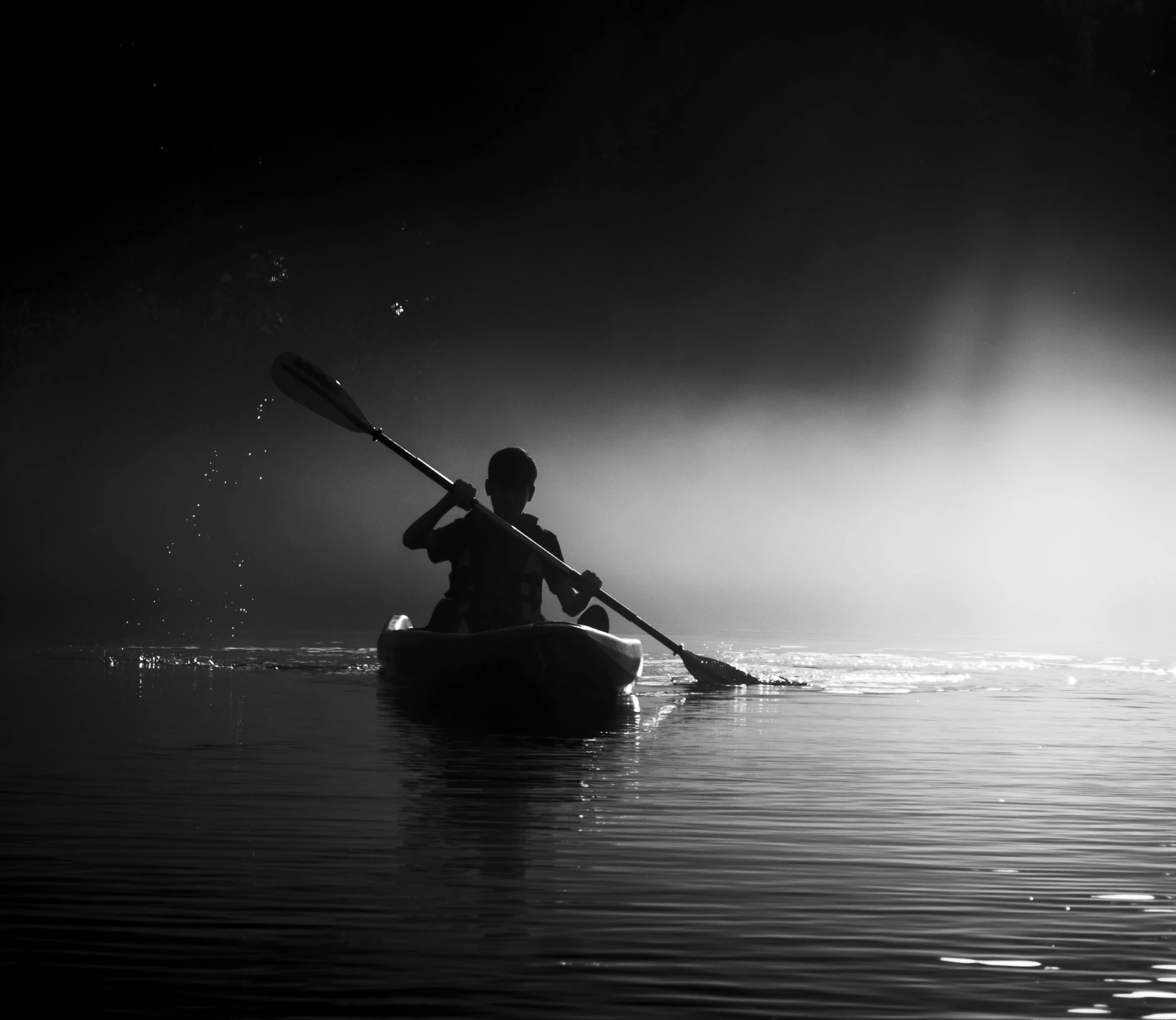 a person is rowing a boat in the dark
