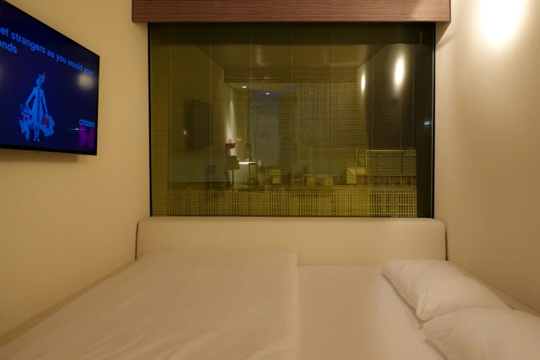 there is a television in the window, next to a bed