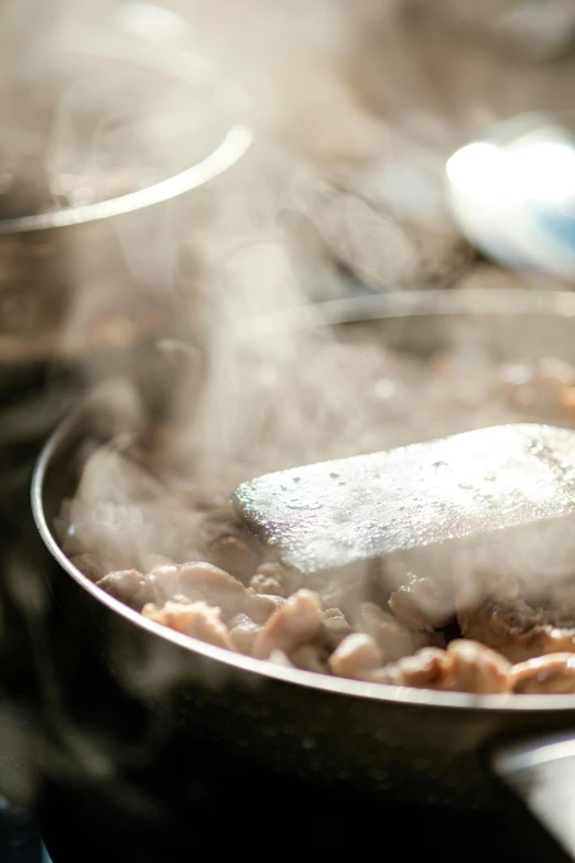 cooking meat is being cooked on an open plate