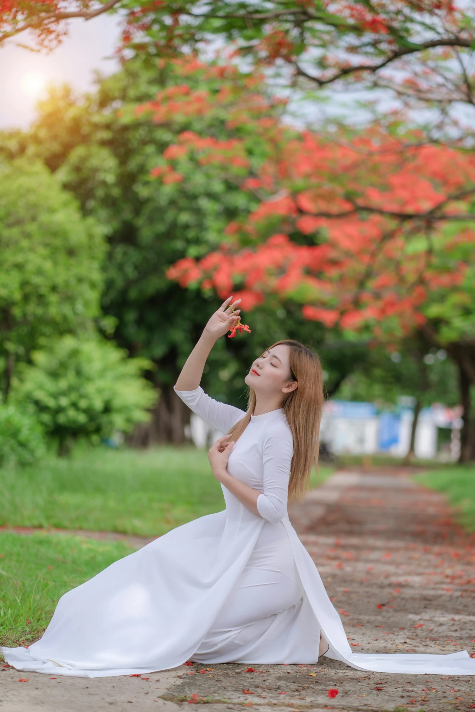 a woman is sitting on the ground, in front of trees