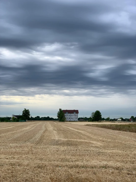 a large field with a barn in the distance