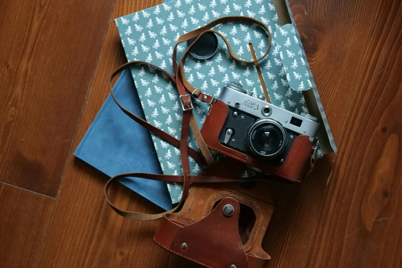 a camera, wallet and an open book on the floor