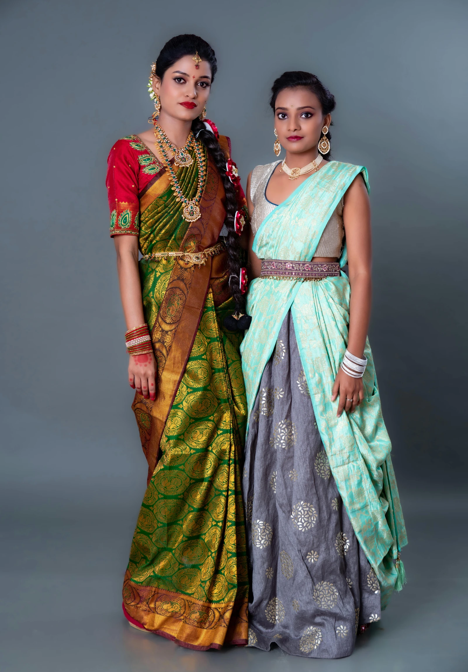 two women wearing matching dress in front of a grey background