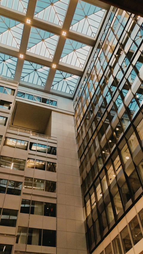 two large buildings with glass windows and a skylight