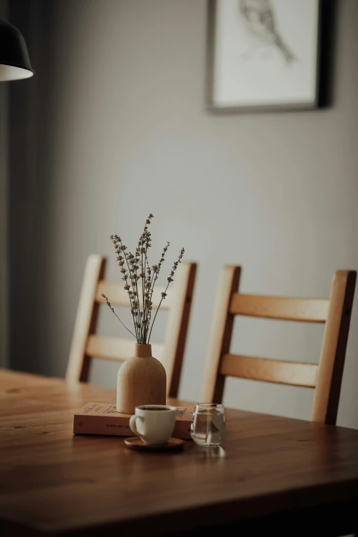 a vase with plants is on top of a wooden table